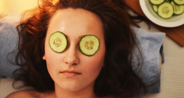 Woman with cucumbers over eyes