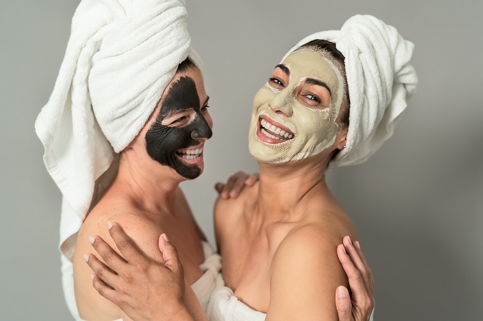 Happy middle aged women on facial mask at the spa