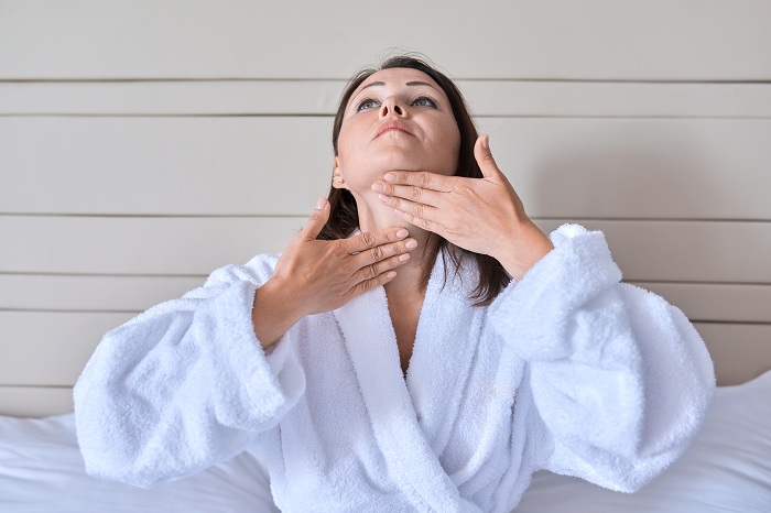 Middle aged woman doing facial massage to remove fine lines