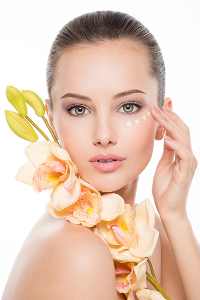 Woman with healthy skin applying eye cosmetics