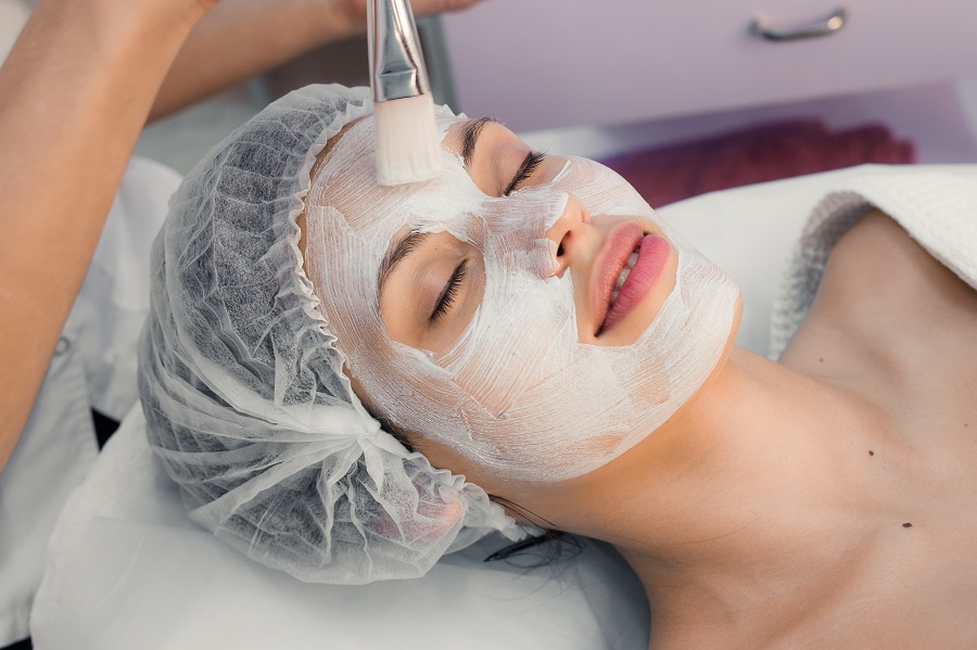 applying mask on a woman's face at the spa