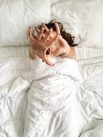 Woman waking up in a white and clean bed