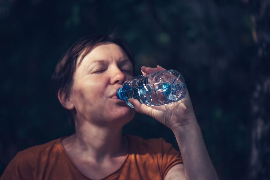woman with dark circles around eyes drink water