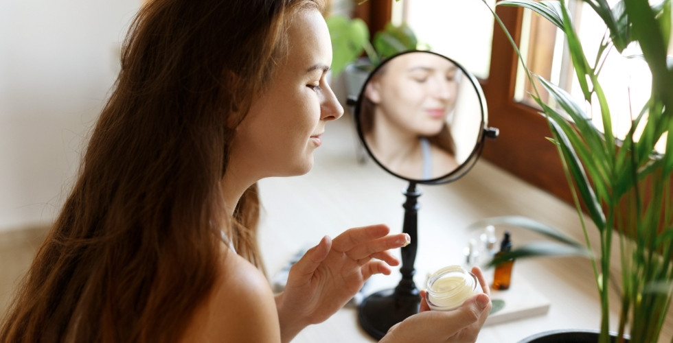 young woman applying face cream